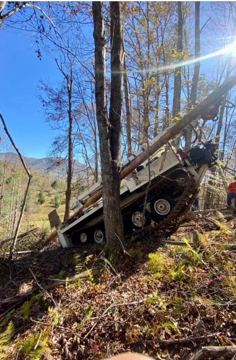 Tracked rig setting a pole on a mountain slope